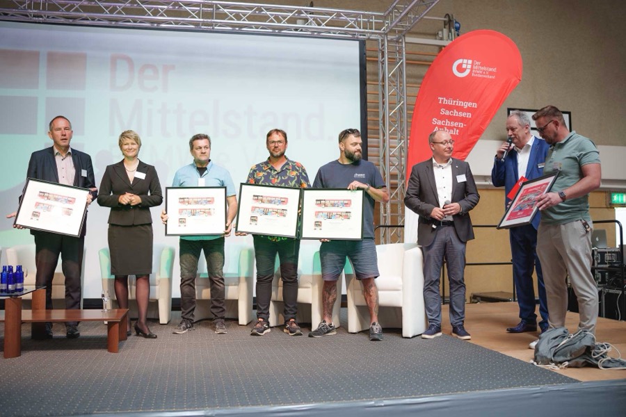 Gruppenbild mit Bilderrahmen auf der Bühne